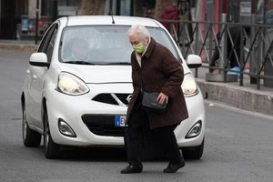 2020年3月13日，在意大利首都羅馬，一位老人戴口罩出行。（圖源: 新華社）