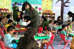 廣平省公安廳女幹部向契溪分校學生贈送禮物及關照他們的午餐。