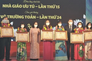 市委副書記、市人民議會主席阮氏麗與市委委員、市人委會副主席楊英德向各教師頒發優秀教師稱號。（圖源：越通社）