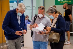 旅客在南非開普敦國際機場查看新冠病毒檢測結果。（圖源：新華社）