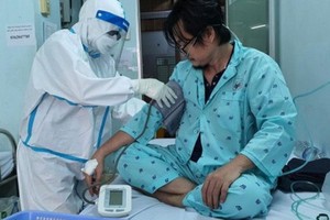 裴氏醒護士正為新冠病人測量血壓。