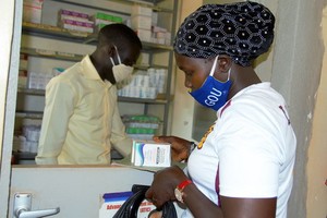 在新冠大流行期間，一名感染艾滋病毒的婦女在烏幹達的一個健康中心取藥。（圖源：聯合國）