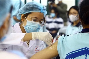 醫護人員為民眾接種疫苗。（圖：越通社）