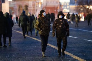 12月11日，人們戴著口罩走在俄羅斯莫斯科紅場上。（圖：新華社）