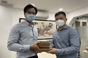林昌耀（左）代表林麗冰把朱愛群的紀念冊和老書籍交給陳列室保管。