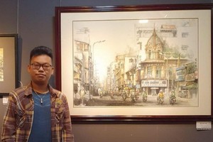 年輕華人畫家張家俊與作品《堤岸區》。