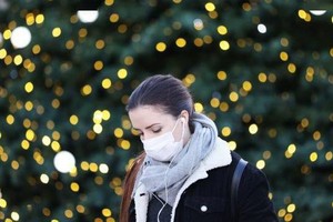 為遏制新冠病毒奧密克戎變異傳播，法國首都巴黎18日宣佈取消原定新年前夕在香榭麗舍大街舉行的煙花表演等慶祝活動。圖為 12月9日，一名女子戴口罩走在法國巴黎街頭。（圖：新華社）