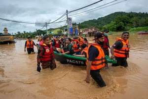 12月19日，在馬來西亞雪蘭莪州烏魯冷岳，救援人員轉移受洪水圍困的災民。連日降雨導致馬來西亞部分地區發生洪災。（圖：新華社）