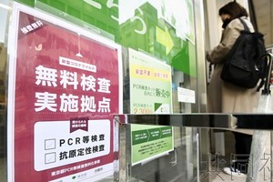 12月25日上午，在JR新橋站前的PCR檢測中心，貼著“免費檢測實施據點”的紙張。（圖：共同社）