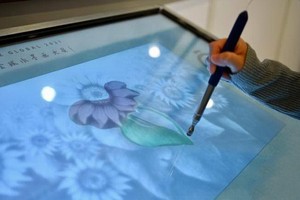 參觀展覽人士使用多媒體設備為水墨畫作填色。（圖：互聯網）
