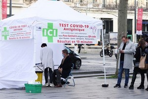 人們在法國巴黎一處新冠病毒檢測點排隊等待檢測。（圖：新華社）