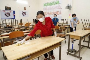 阮攸高中學校職工打掃課室準備迎接學生返校。