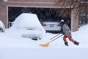 加拿大多倫多居民清理住宅門前的積雪。（圖：互聯網）