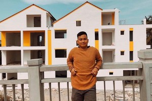 黎文軍後面是去年初建設的酒店。