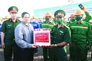 政府總理范明政向項目施工的工程師與工人贈送禮物。