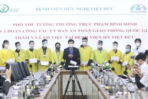 政府常務副總理范平明（中）同越德友誼醫院領導、醫務工作人員合照。（圖：越通社）