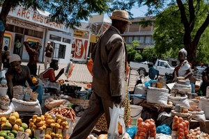 一名男子走過布拉瓦約露天市場的水果攤。（示意圖：互聯網）
