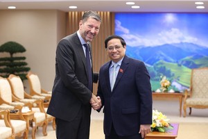 政府總理范明政（右）與阿迪達斯集團總經理羅斯特德握手合照。（圖：楊江）