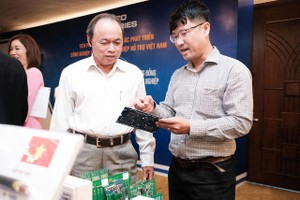 中南EMS股份公司經理阮英輝（右）在2022年峴港配套工業對接會議上介紹了該企業生產的電路板。（圖：晉力）