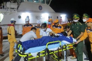 救護隊伍將海上遇險的船員送上岸救治。（圖：越通社）