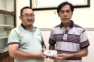 雙龍慈善組副組長羅展明(左)將首期款項移交淩欽廷副董事長。