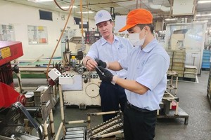 越南Mtex有限責任和公司黨支部書記鄧明山（左）與黨員交換意見。