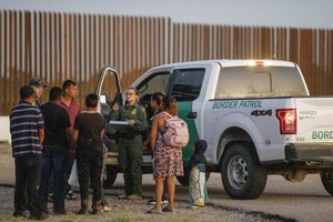 美國邊境巡邏人員在美國得克薩斯州伊格爾帕斯附近詢問移民。（圖：新華社）