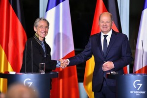 德國總理朔爾茨（右）同法國總理博爾內在新聞發佈會上握手。（圖：新華社）