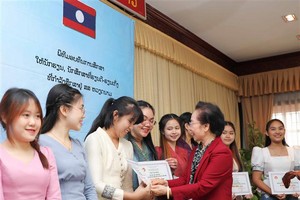 越南助學協會主席阮氏緣向老撾留學生頒發助學金。（圖：青松）