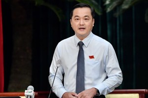 市工商廳廳長裴佐黃宇在會議上回答人民議會代表的質詢。（圖：越勇）