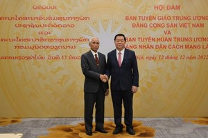 中央宣教部長阮仲義（右）與老撾人民革命黨中央書記、黨中央宣訓部長坎潘‧佩亞翁握手合照。（圖：越通社）