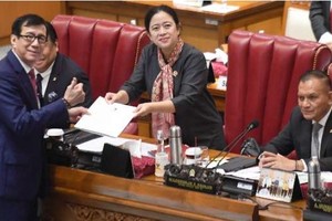 12月15日，在雅加達國會大廈召開的全體會議上，司法人全部長雅索納（左）將關於《印尼和新加坡政府引渡協議法案》總統的最終意見檔案遞交給國會議長普安（右二）。（圖：印尼商報）