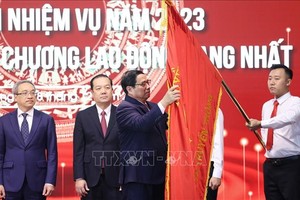 政府總理范明政在新聞與傳播部傳統旗幟別上一等勞動勳章。（圖：越通社）