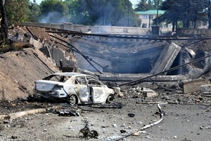 爆炸威力強大，有汽車被波及損毀。（圖：AP）