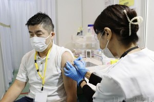 10月14日上午，一名男性正在接種應對新冠疫苗奧密克戎毒株亞型“BA.5”的疫苗。（圖：共同社）