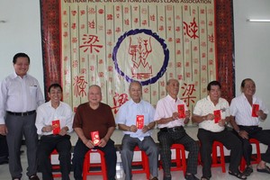 梁氏宗祠理事长梁万荣(左一)向七十岁以上的长者派发敬老礼物。