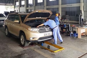 登检工作人员正在检定一辆汽车的引擎。（图：小松）