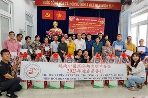 中商会本市分会爱心团与第八郡越南祖国阵线委员会领导和华人贫户合影。