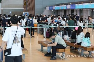 2022年9月14日，在仁川国际机场第二航站楼，旅客们正在排队等待办理登机手续。随着自海外入境韩国前核酸检测规定的废除，出国客流大增。 （图：韩联社）