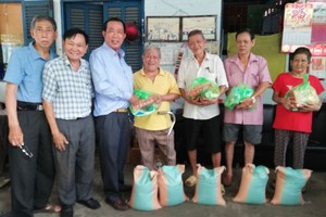 热心厂商杨庆文(左三)和玻璃业团主席李国强(左二)向团员发放新年礼物。