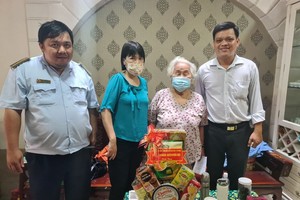 第八坊越南祖国阵线委员会主席徐华隆(右)赠送礼物给荣军。