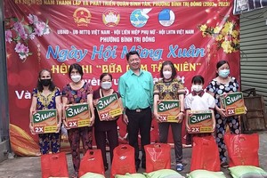 平新郡平治东坊常务副书记阮金龙（中）向环境困难的华人户赠送岁暮礼物。