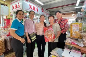 市妇联会副主席陈氏芳华向华人商贩应氏莲赠送春节礼物。