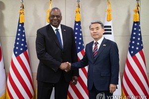 1月31日，在位于首尔市龙山区的国防部大楼，韩国国防部长官李钟燮（右）和美国国防部长劳埃德·奥斯汀握手合影。（图：韩联社）