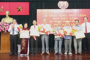 第十郡领导向当地高龄党员颁授党龄纪念章。（图：市党部新闻网）