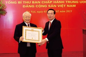 党中央书记处常务书记武文赏向党中央总书记阮富仲颁授55年党龄纪念章。