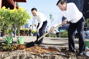 市人委会原主席阮成锋与市委副书记阮文孝参加植树活动。