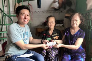 本报社会慈善工作组代表曾广健（左）把善款转交给郑惠卿（右）和郑婉卿俩姊妹。