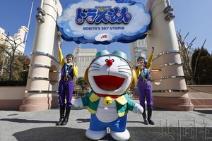 2月22日下午，在USJ的新游乐设施前，工作人员和哆啦A梦一起摆好姿势。（图：共同社）