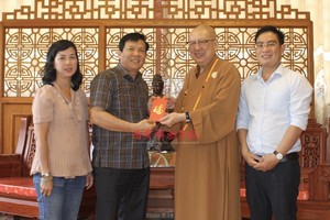 草堂禅寺住持释了明法师（右二）把赞助赠报经费交给本报领导。